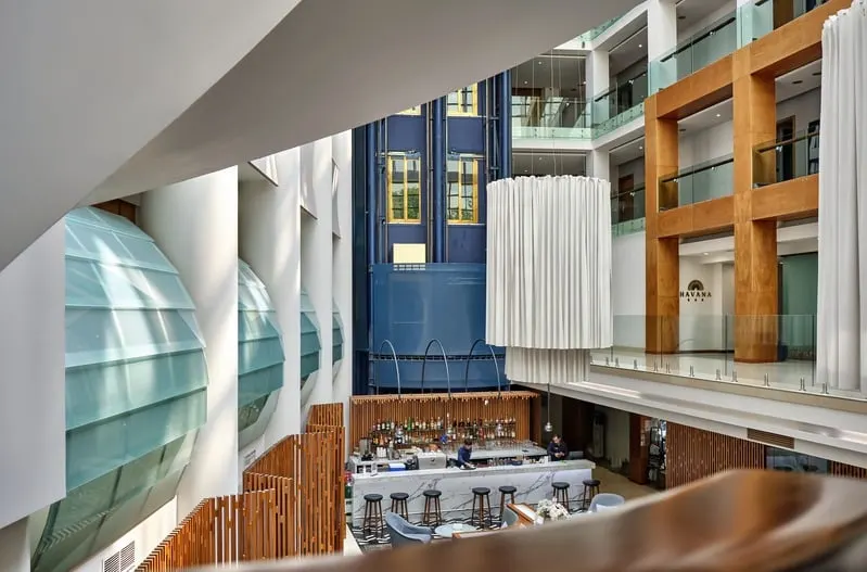 Hotel atrium with a white drum light over the bar